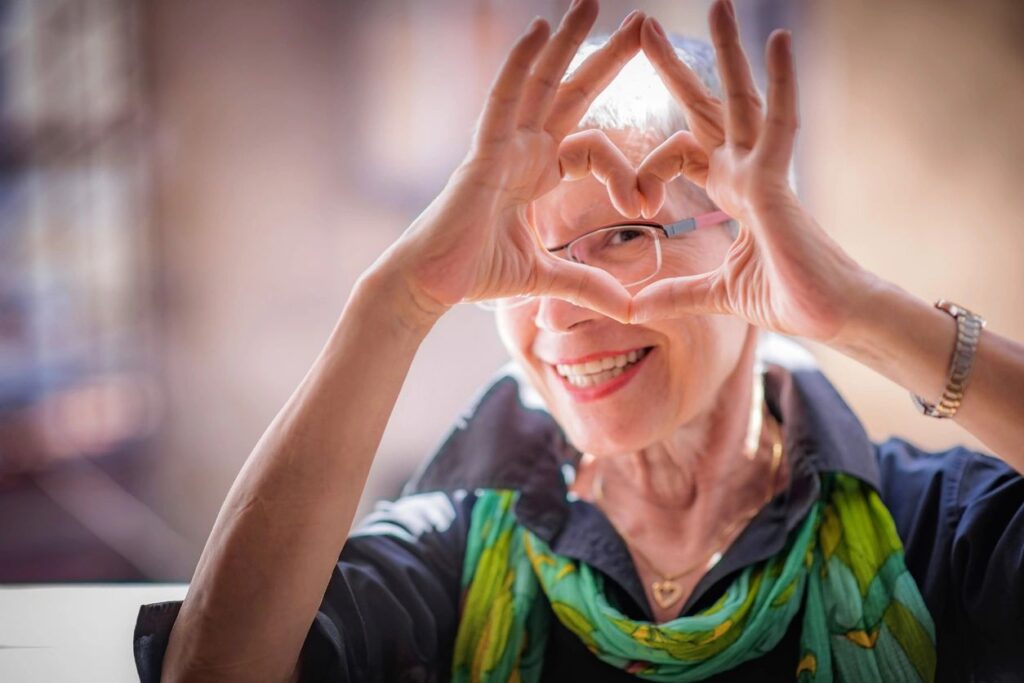 Mature woman making heart shape with hands.  